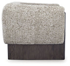 Accent chair with textured oatmeal boucle back panel and dark wood base.
