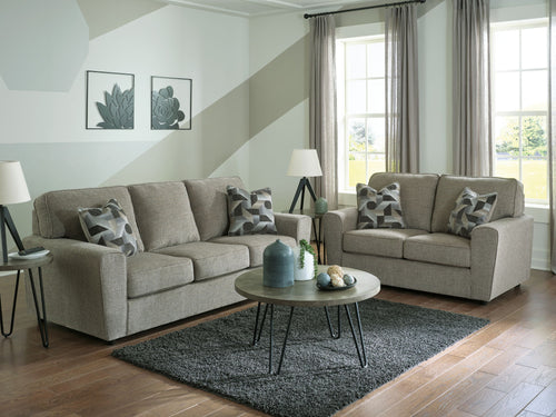 Gray fabric sofa and loveseat set with padded seats and patterned throw pillows