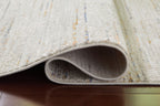 Beige rug corner with rolled edge and visible underside pile