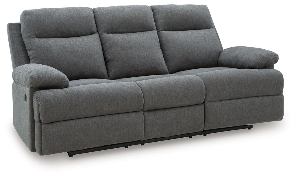 Dark gray reclining sofa with tufted back cushions and padded armrests