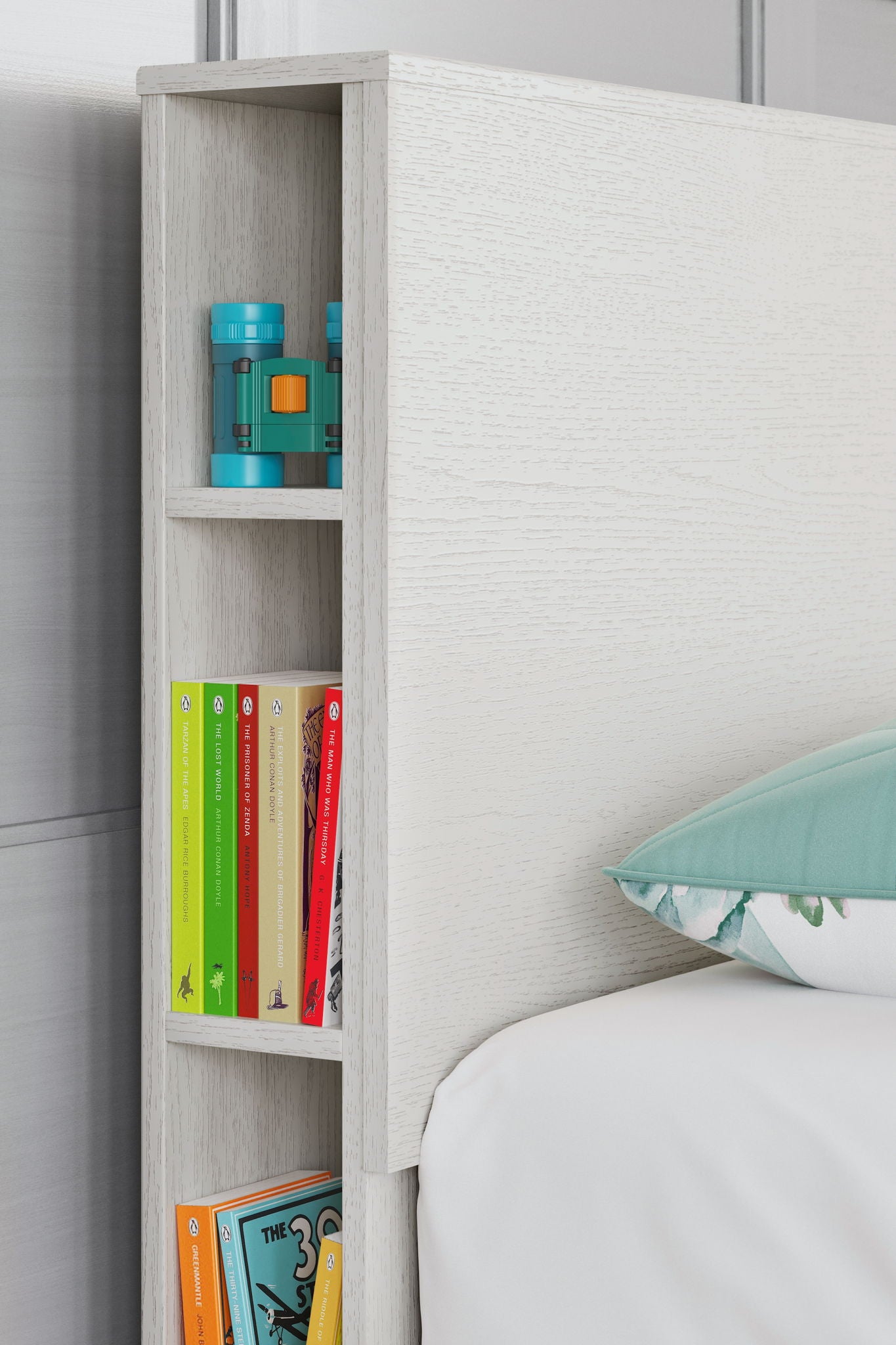 Twin white bookcase headboard with left storage shelves holding books and decor
