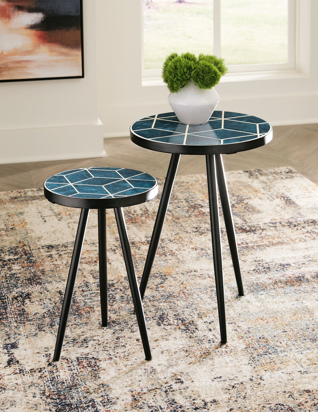 Round accent table pair with teal geometric tops and black tripod legs