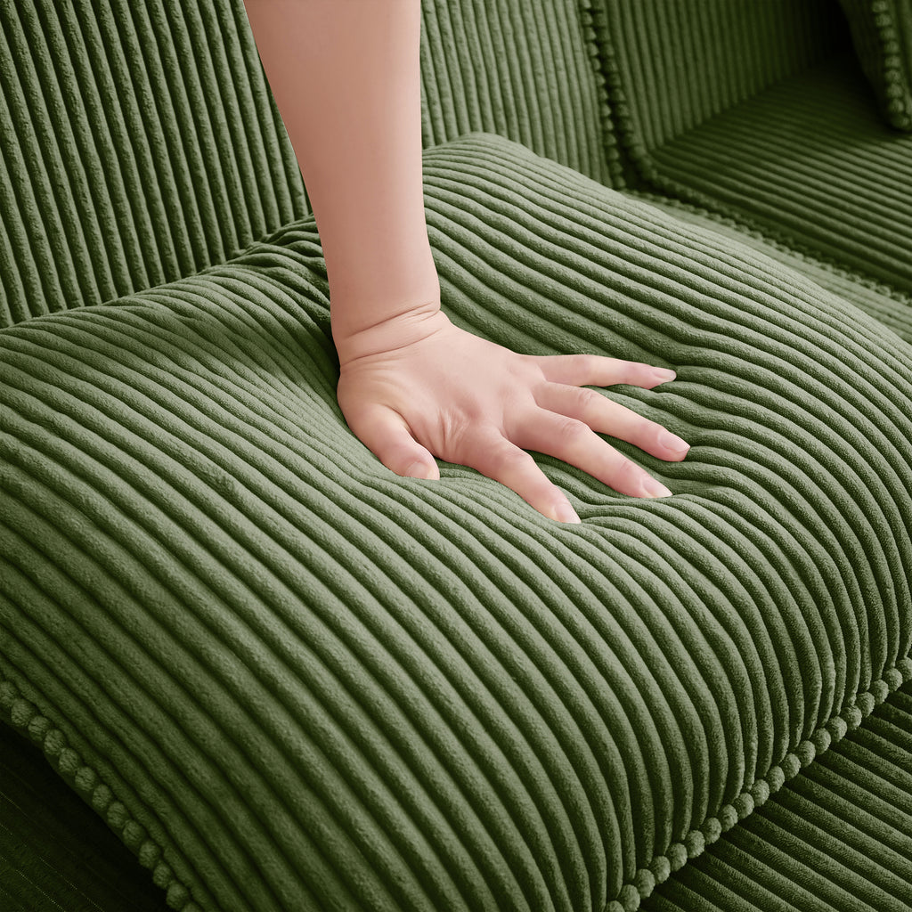 Green corduroy upholstery close-up with hand smoothing ribbed fabric