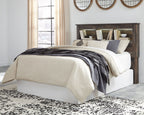 Bookcase headboard with white bed, beige and gray bedding, dark wood shelves