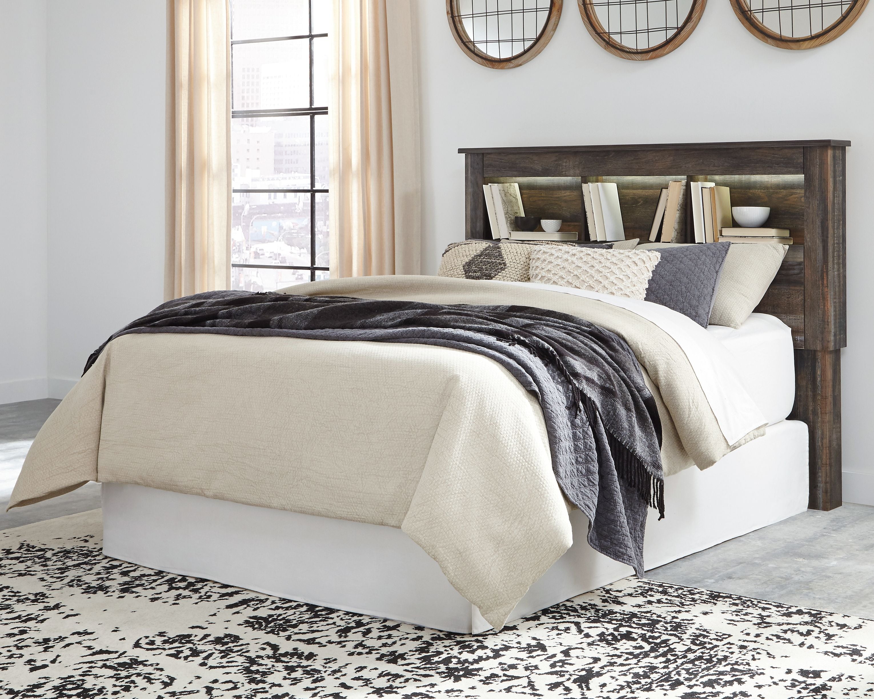 Bookcase headboard with white bed, beige and gray bedding, dark wood shelves