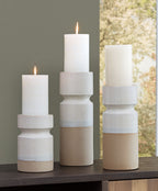 Set of 3 candle holders with lit white candles in ivory-and-brown stacked cylinders