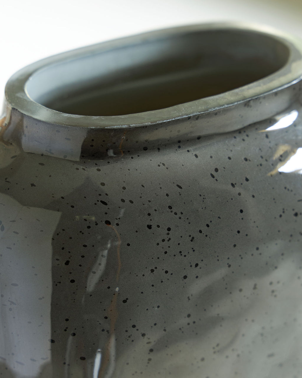 Close-up of vase rim and interior, dark speckled ceramic finish