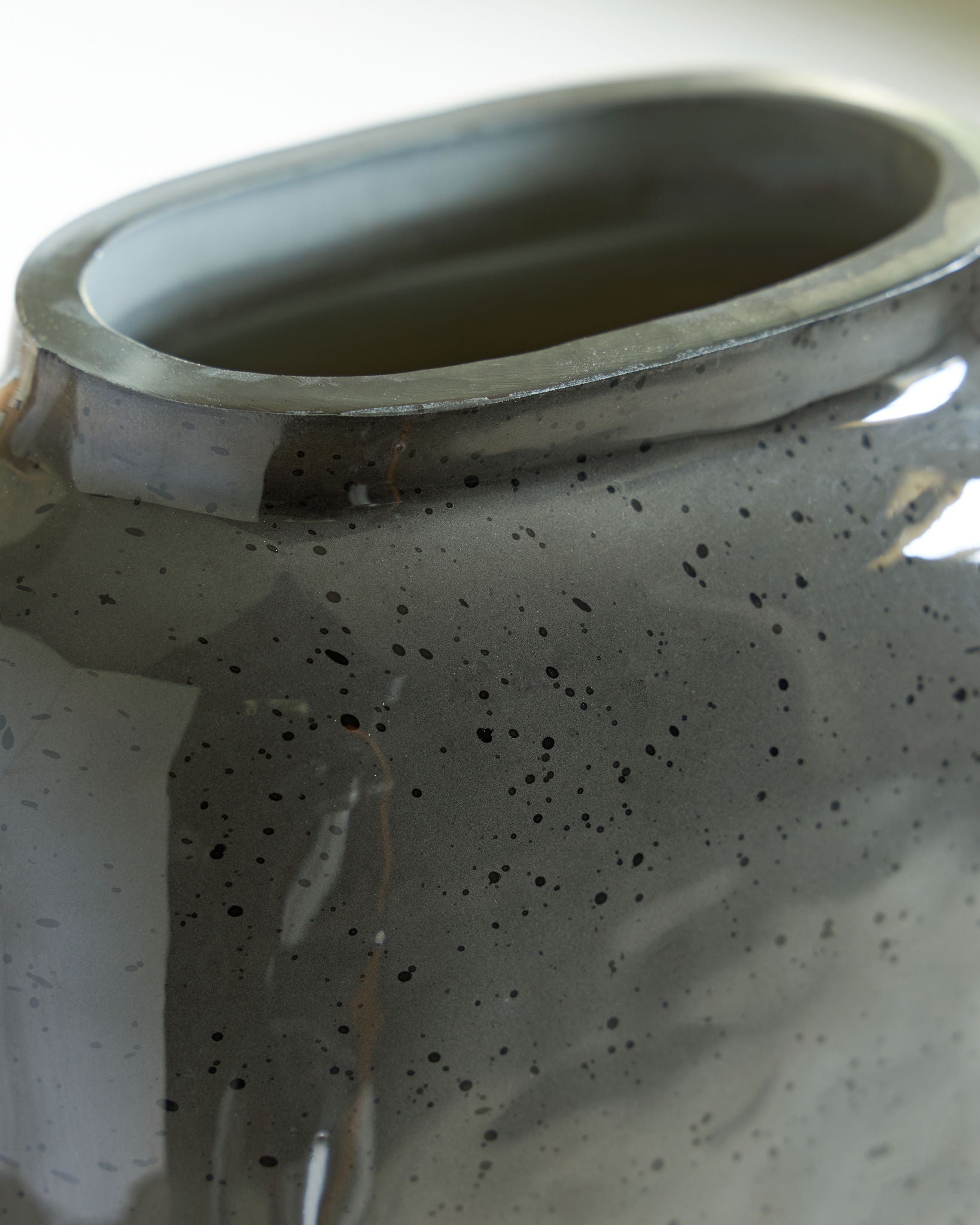 Close-up of vase rim and interior, dark speckled ceramic finish
