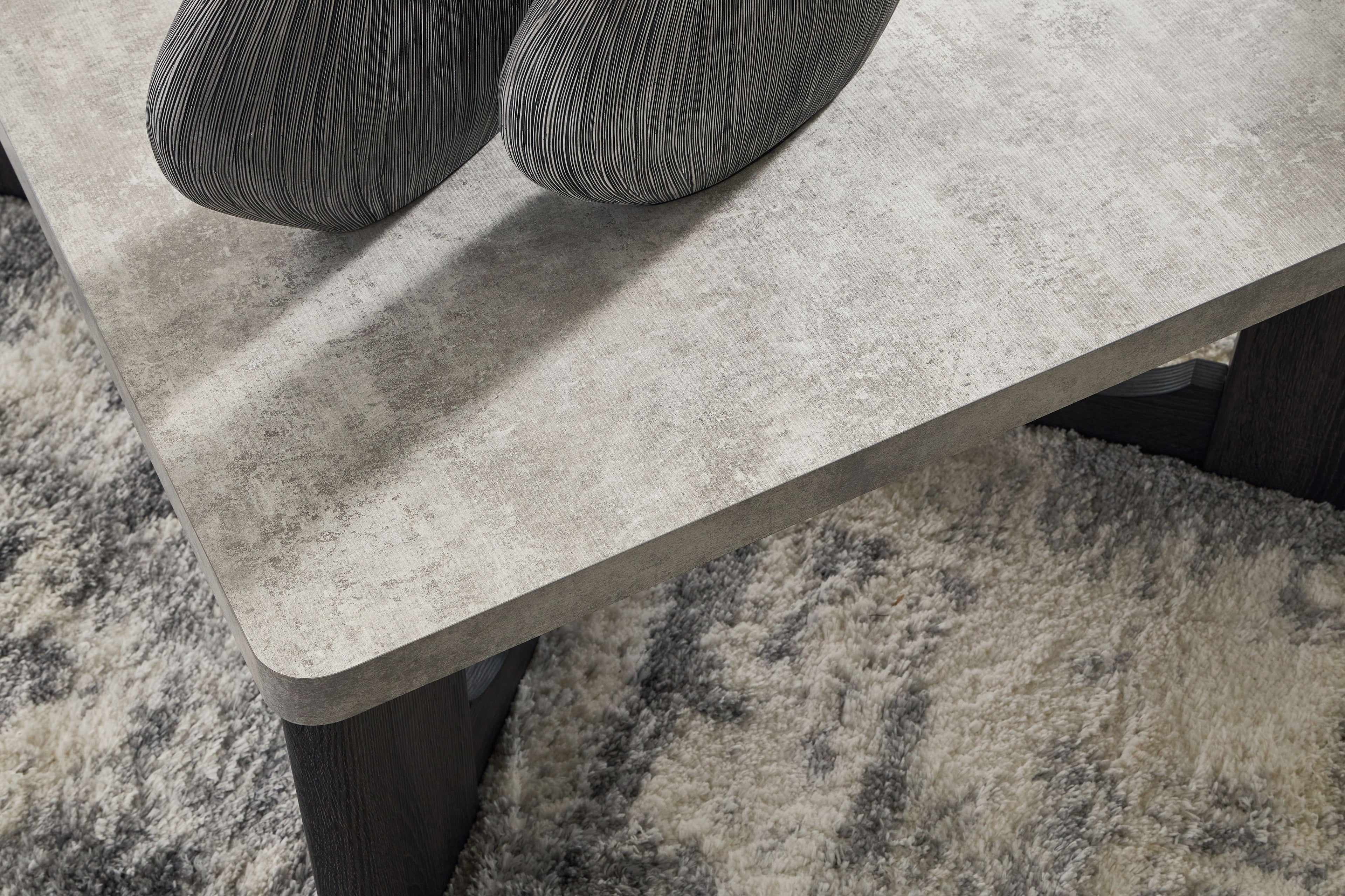 Gray square table top with beveled edge and dark X-style legs, close-up