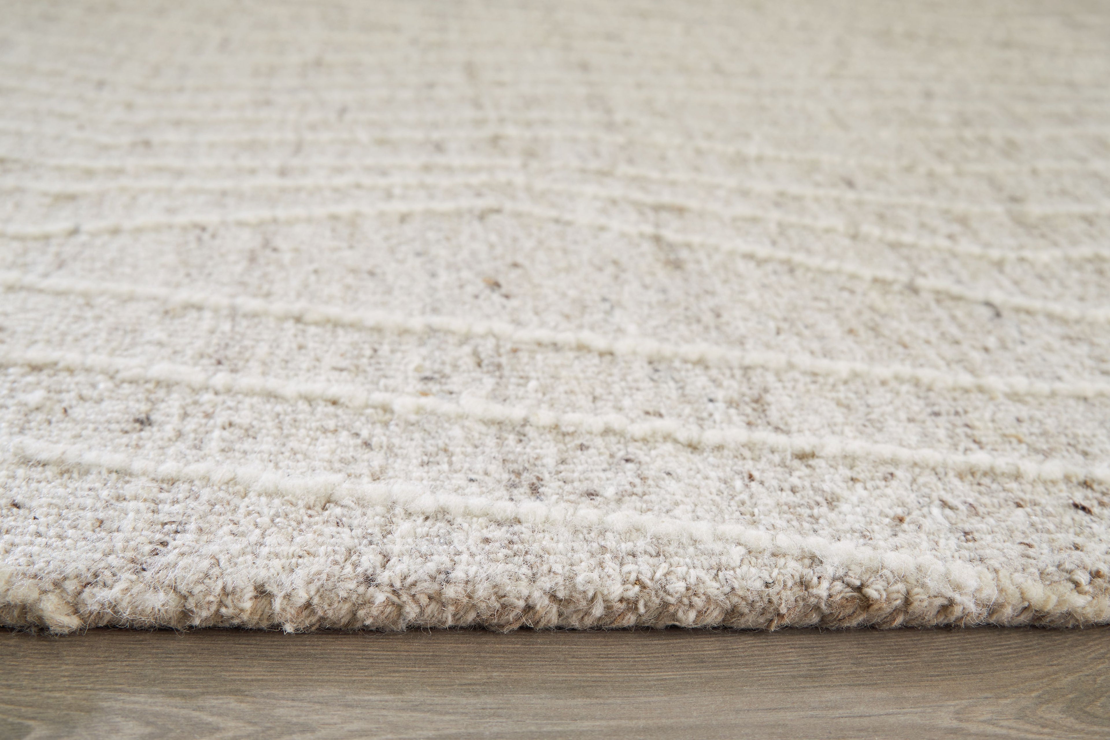 Cream rug edge with short textured pile visible along the border