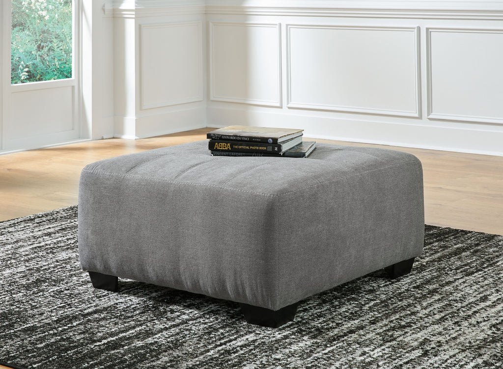 Gray oversized ottoman with thick padded seat and tapered black legs