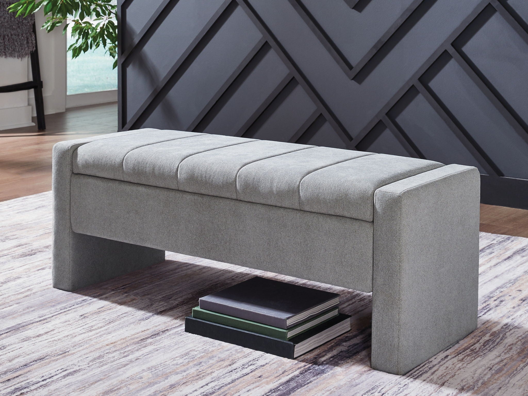 Gray storage bench with padded seat and hinged lid; shows solid side arms