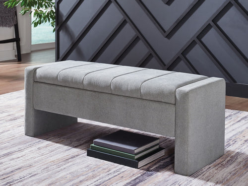 Gray storage bench with padded seat and hinged lid; shows solid side arms
