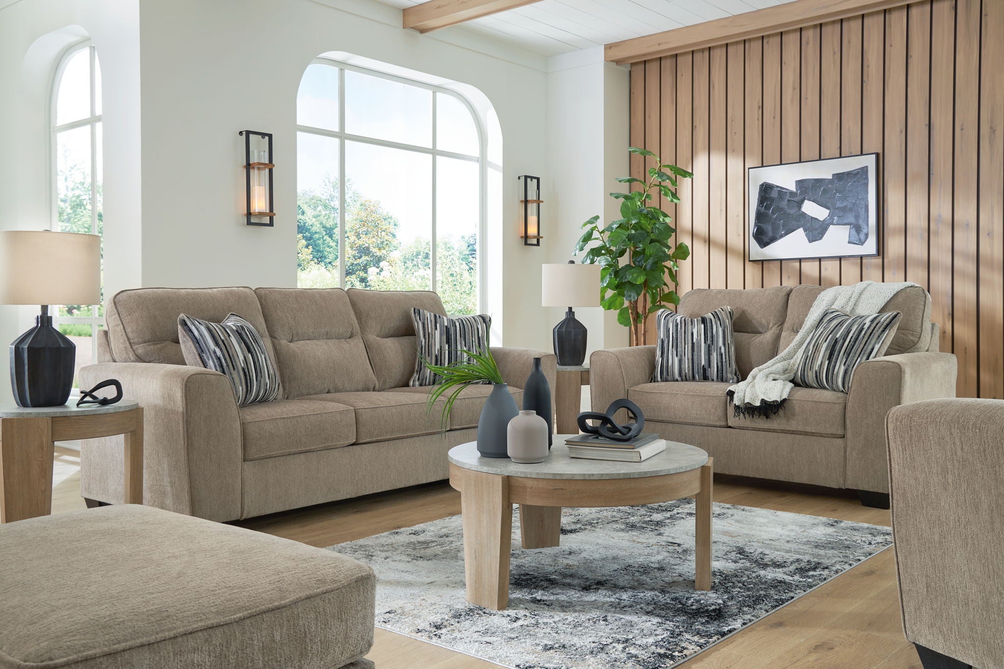 Light brown fabric living room set with striped pillows and coordinating ottoman