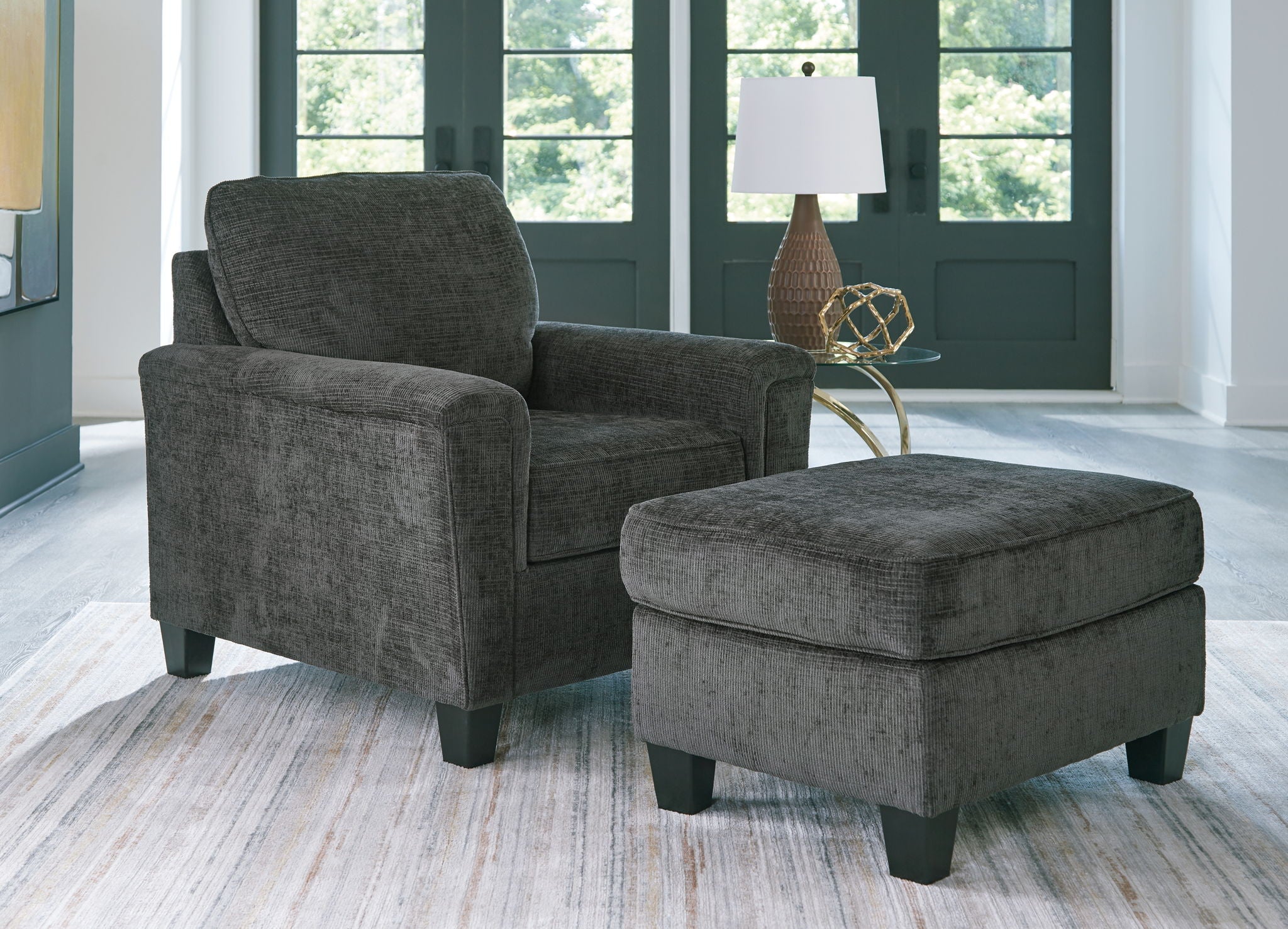 Black upholstered armchair with matching ottoman and fabric seat