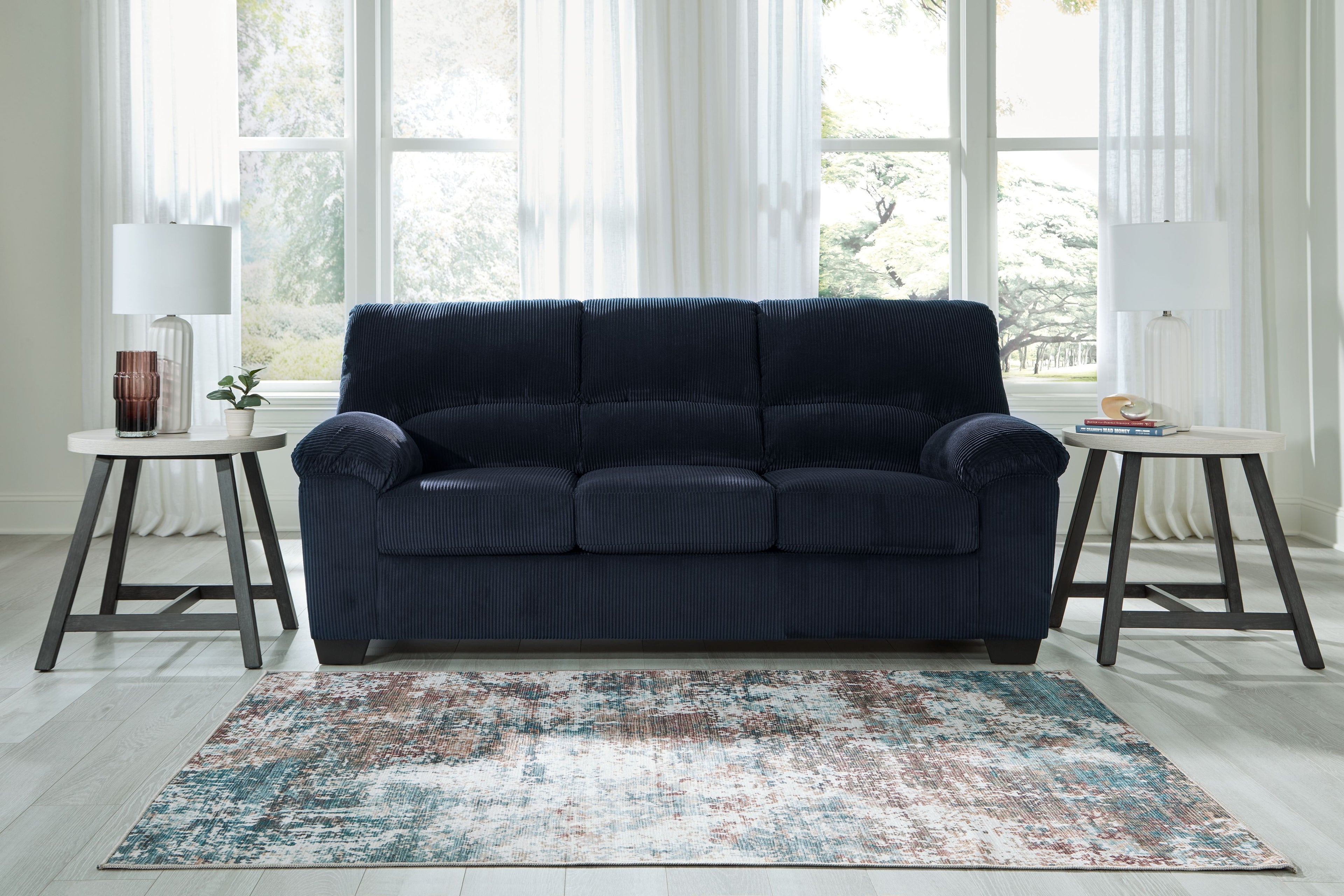 Navy corduroy sofa with three seat cushions and rolled armrests