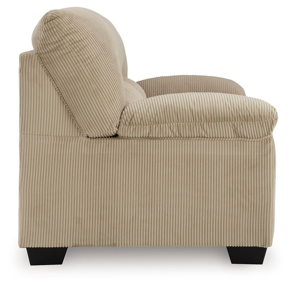 Beige corduroy loveseat with rolled armrest, thick back cushion, and dark legs