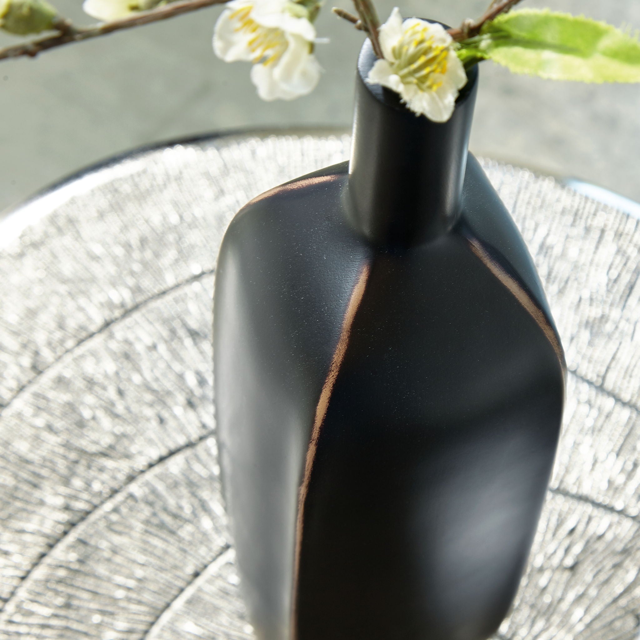 Rhaveney black vase close-up with vertical bronze stripe on matte surface