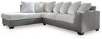 Light gray sectional sofa with chaise, striped throw pillows, and boxy armrests.