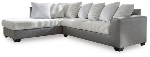 Light gray sectional sofa with chaise, striped throw pillows, and boxy armrests.