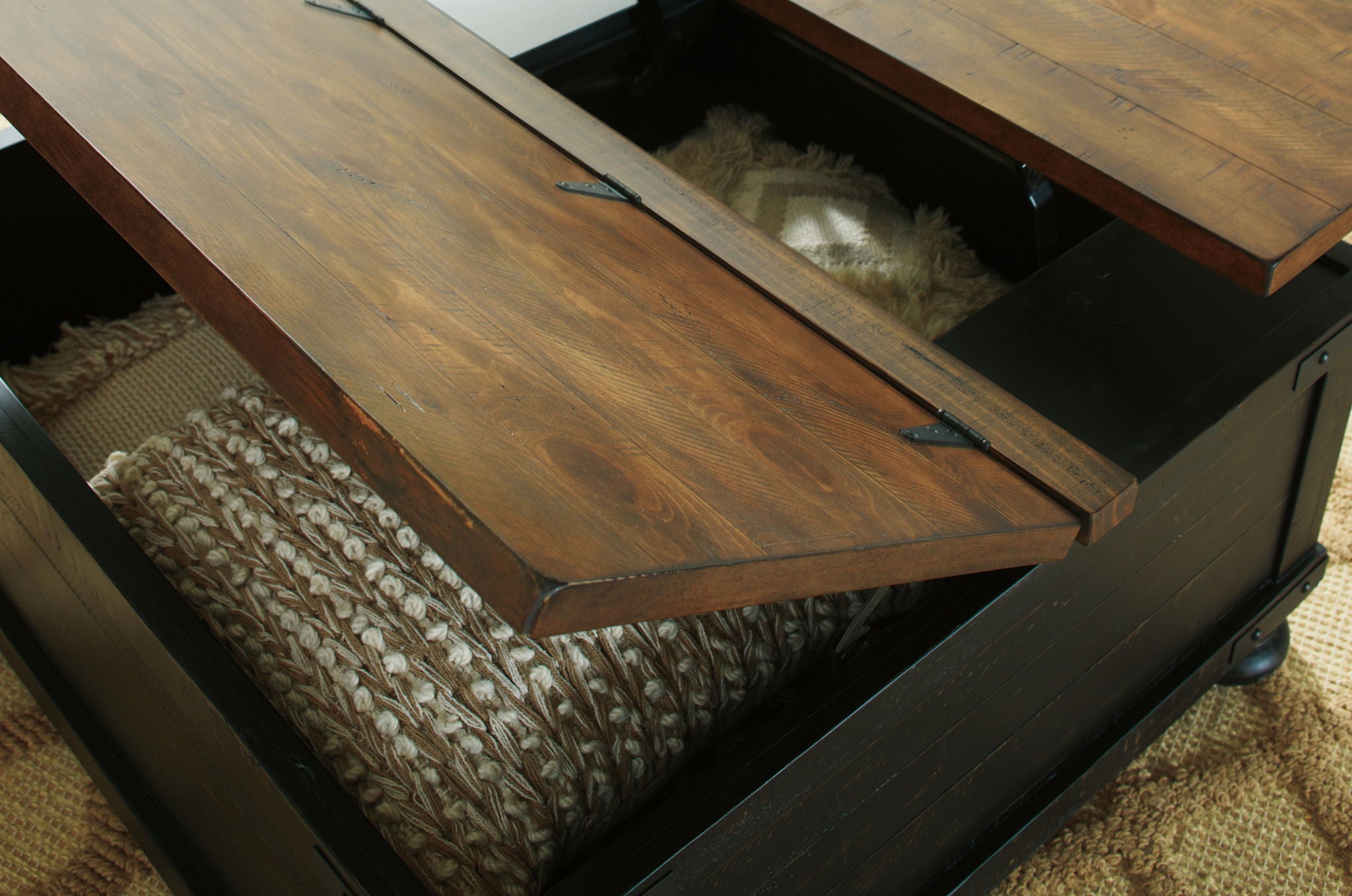 Lift-top cocktail table with raised lid, black base and brown interior shelf