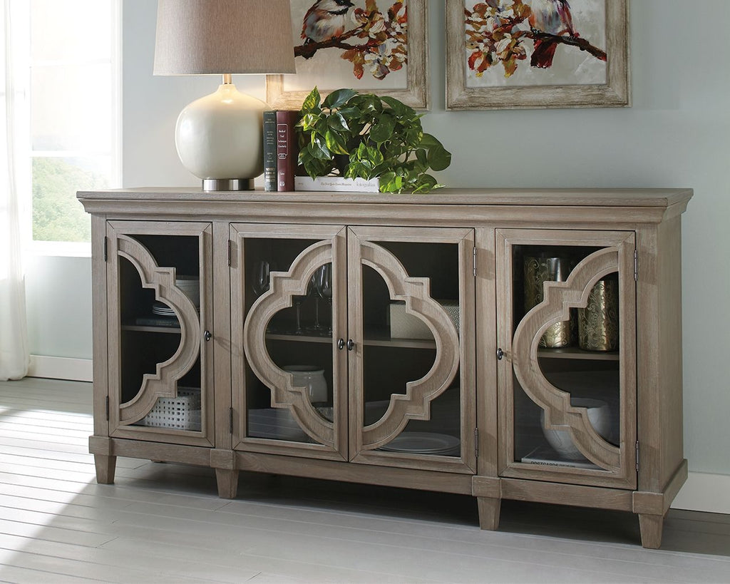 Gray accent cabinet with four doors and carved quatrefoil panels