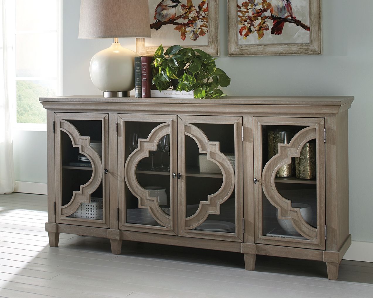 Gray accent cabinet with four doors and carved quatrefoil panels