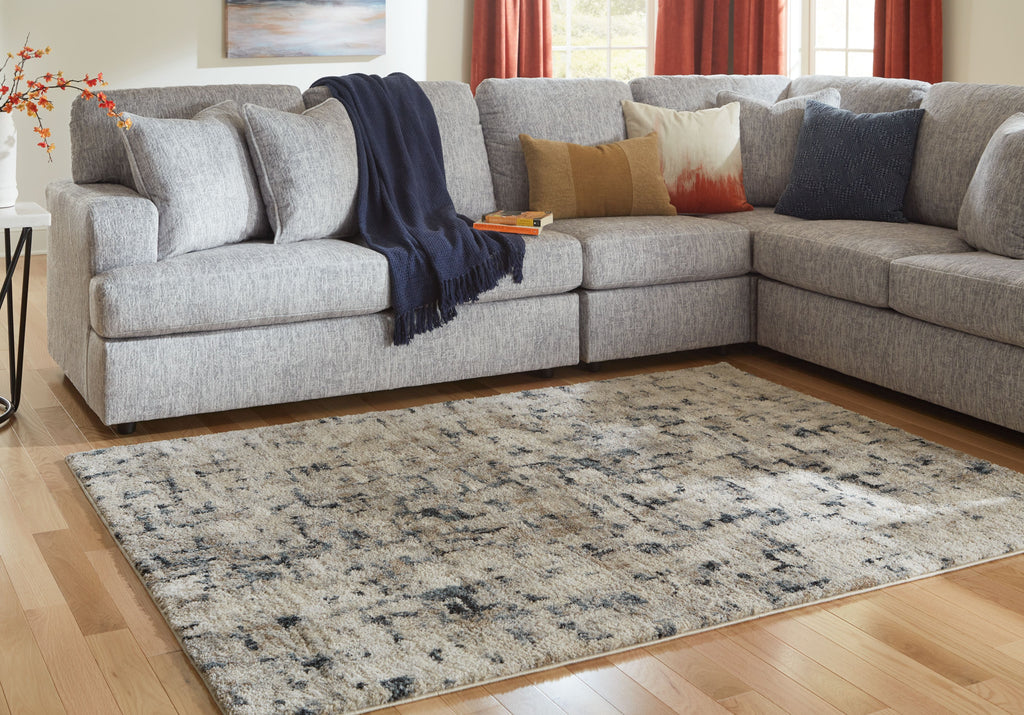 Grey and off-white abstract area rug with distressed pattern; rectangular edge visible