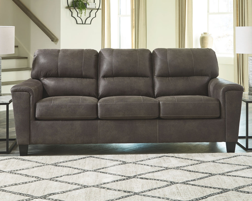 Dark gray three-seat sofa with tufted back cushions and padded armrests