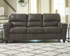 Dark gray three-seat sofa with tufted back cushions and padded armrests