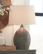 Table lamp with textured gray ceramic base and beige drum lampshade