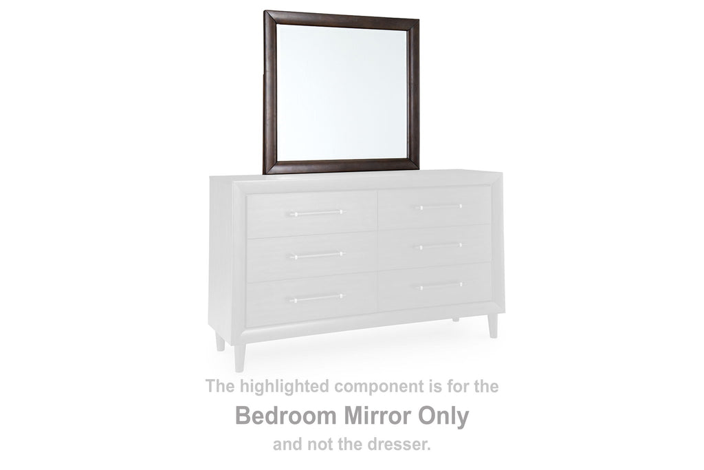 Bedroom mirror with merlot frame set atop white drawer dresser