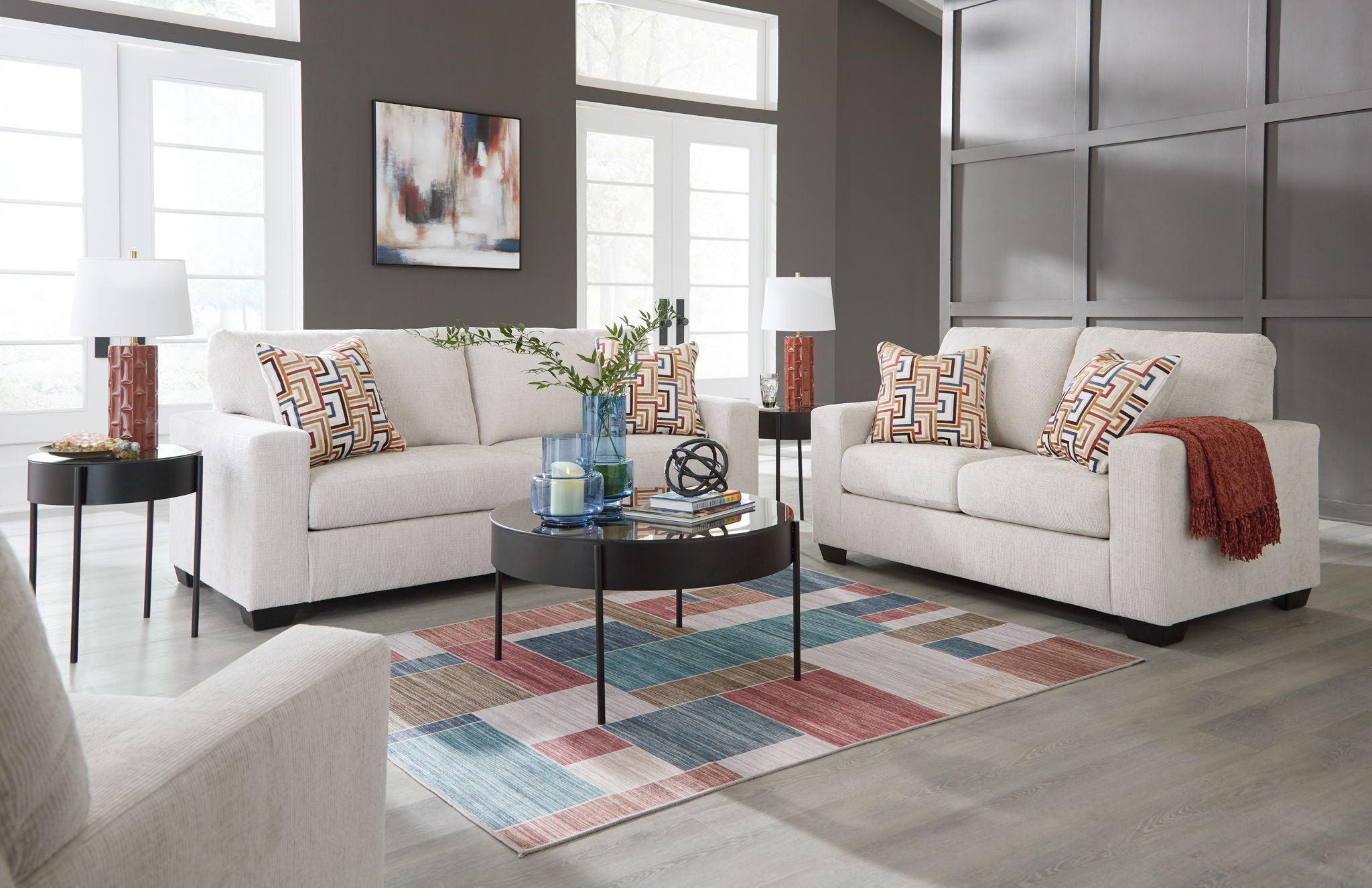Light gray sofa and loveseat with patterned pillows