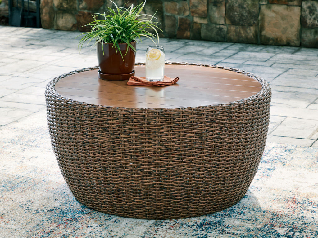 Round cocktail table with woven wicker base and wooden tabletop