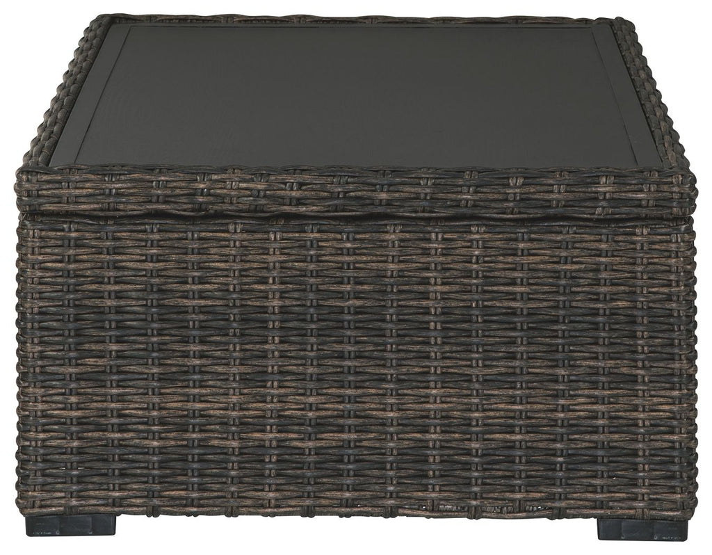 Rectangular brown wicker cocktail table with black tabletop and flat base