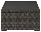 Rectangular brown wicker cocktail table with black tabletop and flat base