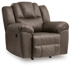 Dark brown rocker recliner chair with cushioned arms, tufted back, and side control