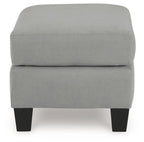 Gray upholstered ottoman with padded top, square base, and dark legs