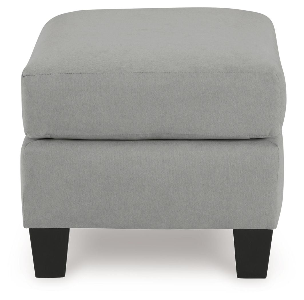 Gray upholstered ottoman with padded top, square base, and dark legs