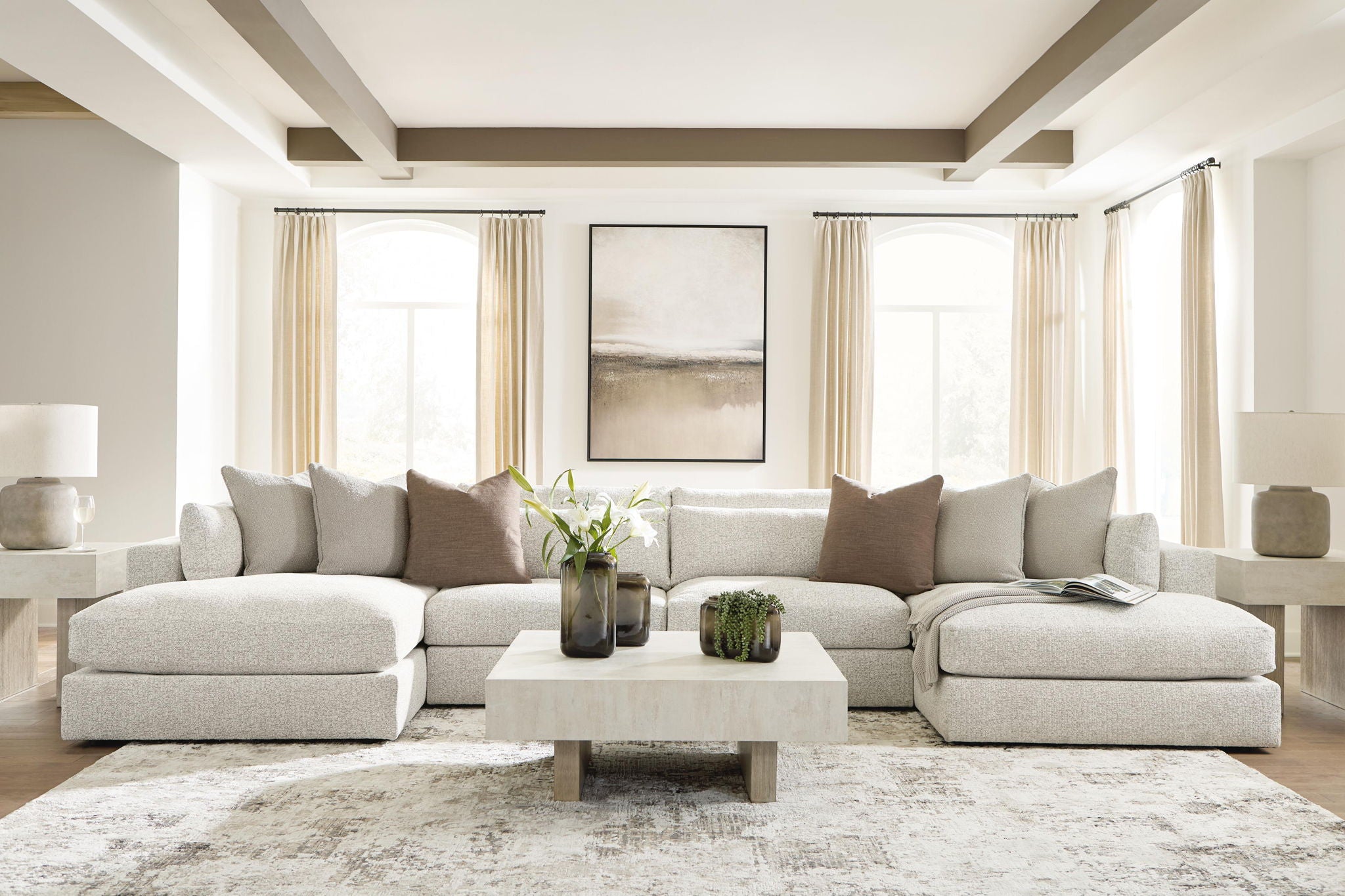 Beige sectional sofa with chaise, cushioned back and arms, styled with pillows and a coffee table