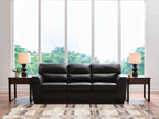 Dark leather sofa with three seat cushions and tufted back, wide boxy arms