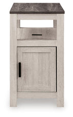 Chair side end table in light whitewashed wood with open shelf and cabinet door with black pull