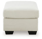 Cream upholstered ottoman with ribbed fabric, rounded lid, and dark square feet
