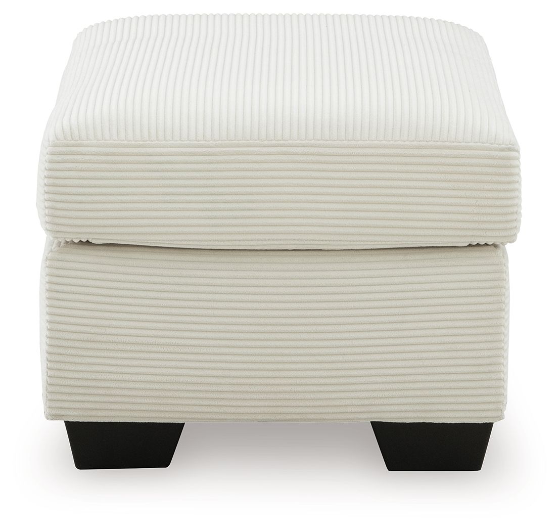Cream upholstered ottoman with ribbed fabric, rounded lid, and dark square feet