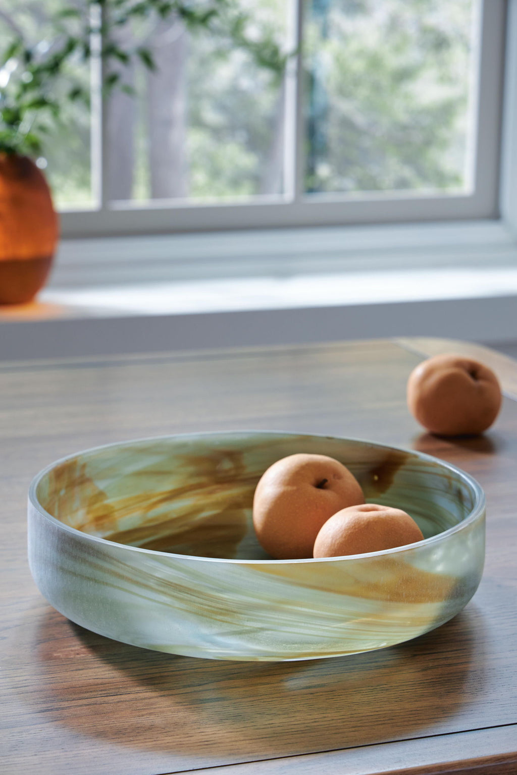 Sage green marbled glass bowl with three round fruits
