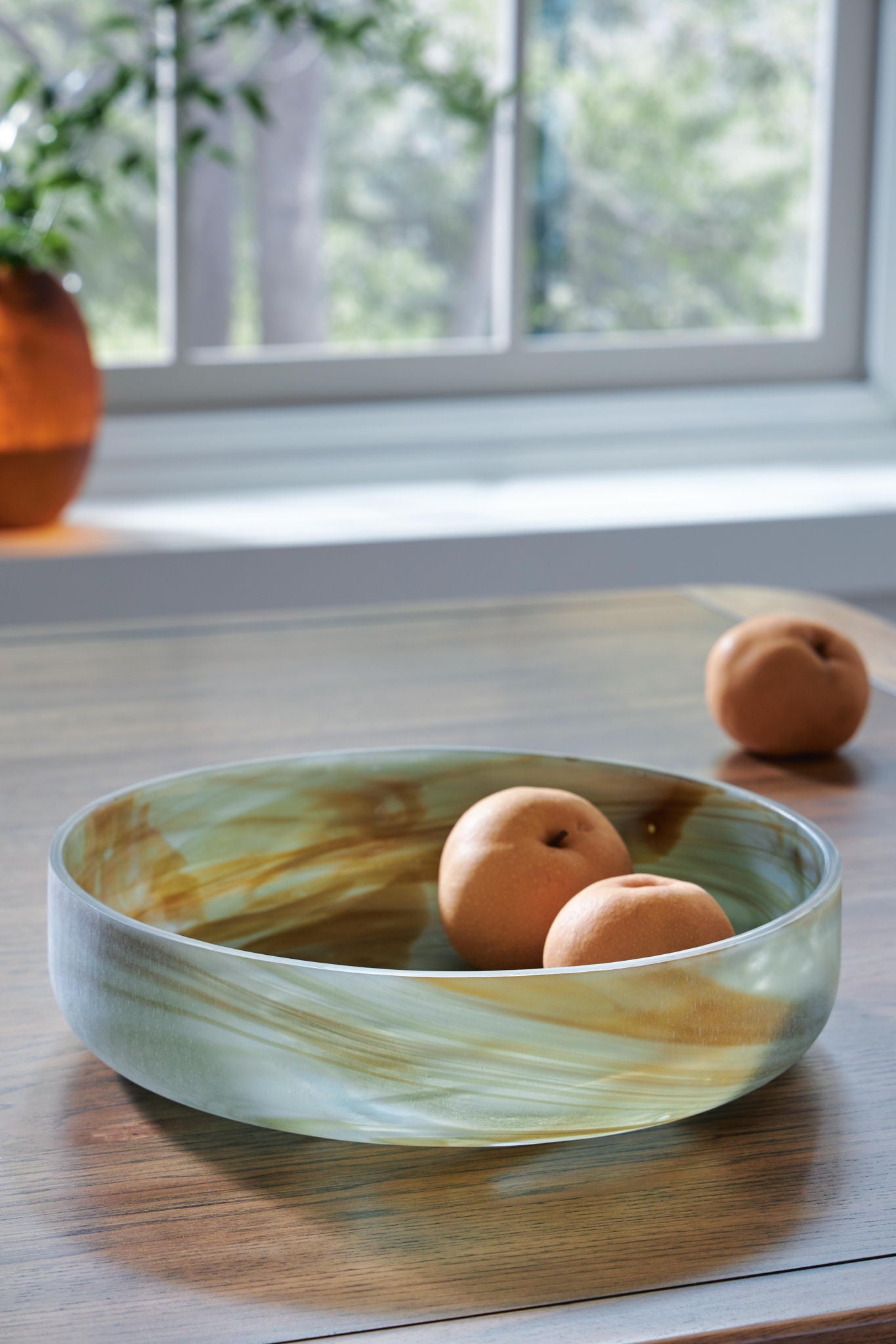 Sage green marbled glass bowl with three round fruits