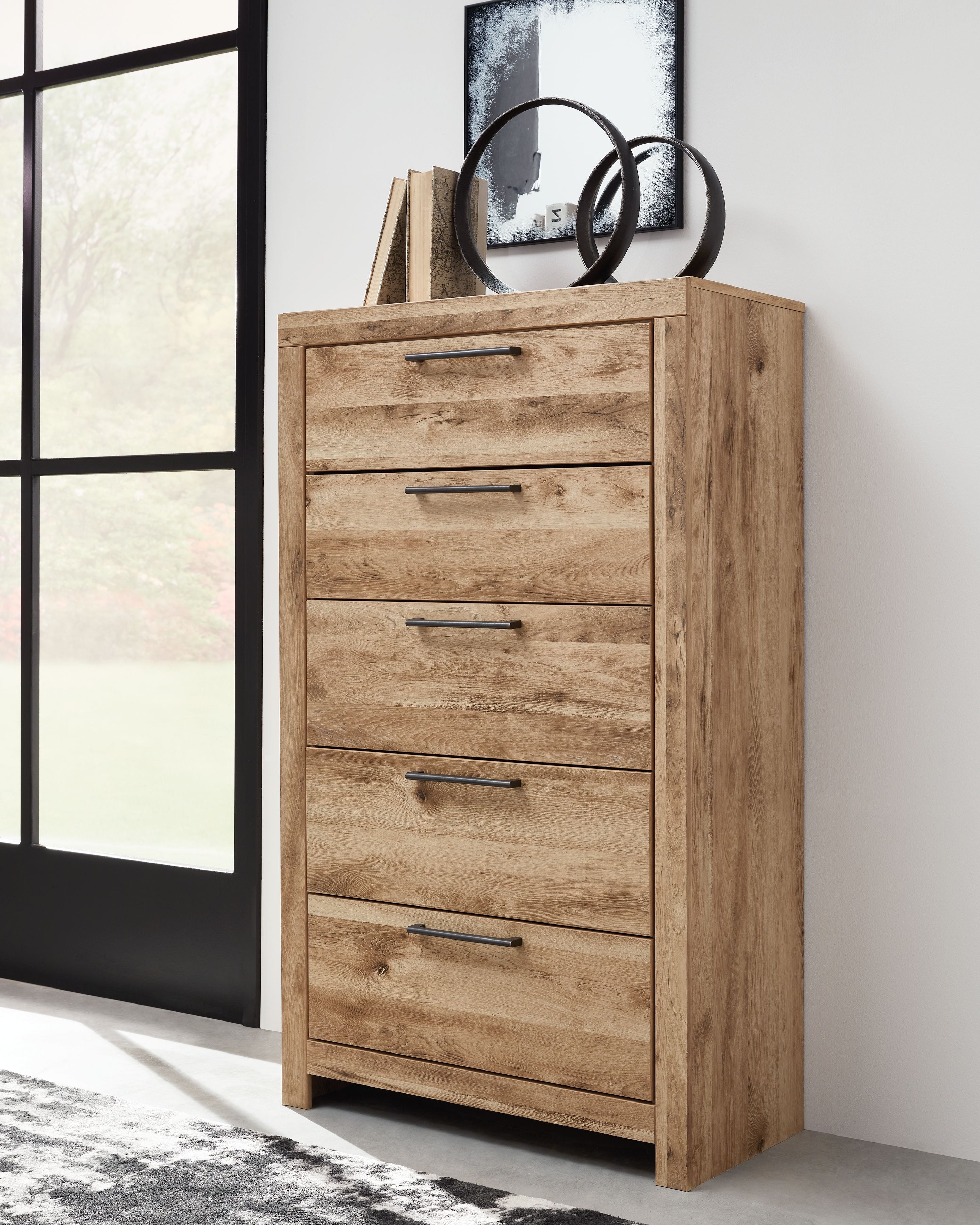 Tan brown five-drawer chest with five drawers and metal bar pulls, angled view