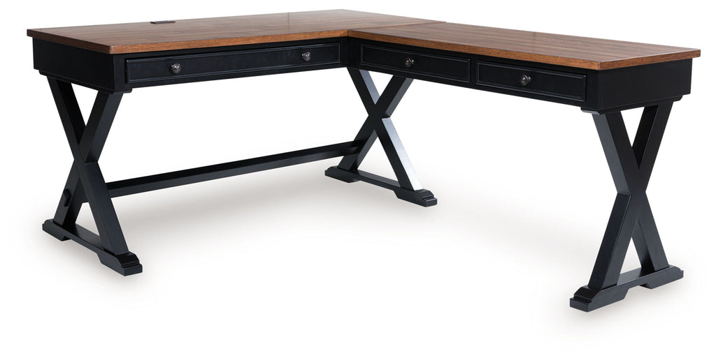 Home office desk with brown wood top, dark X-frame legs, and drawer panel