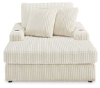 Corduroy chaise lounge chair in off-white with thick seat cushion and two side arms.