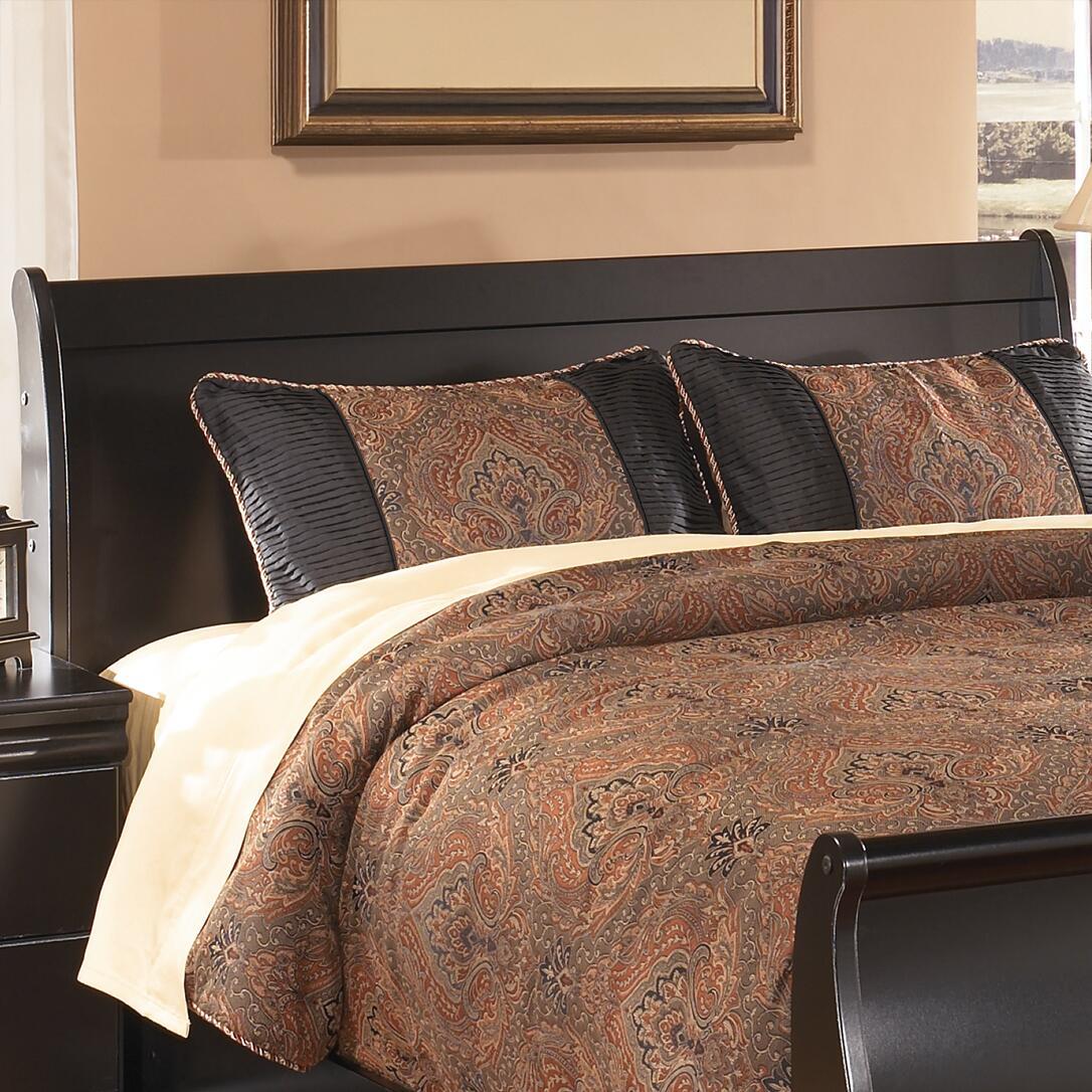 Black queen sleigh headboard with curved upholstered top, styled with patterned bedding
